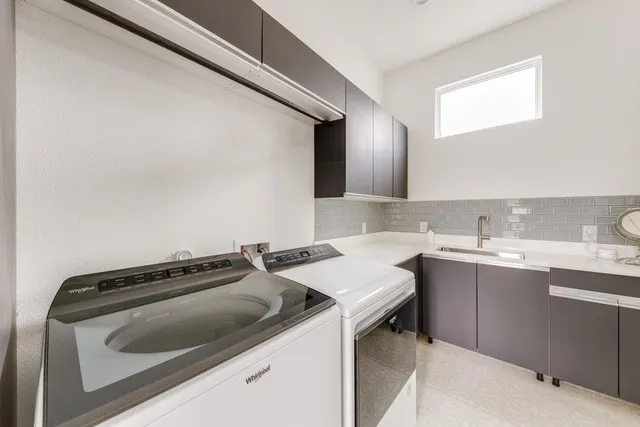 a utility room with sink dryer and washer
