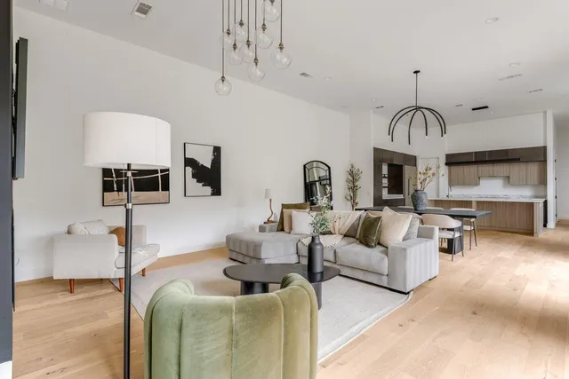 a living room with furniture a large window and kitchen view