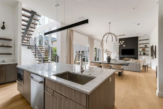 a kitchen with stainless steel appliances a sink a stove and a wooden floors