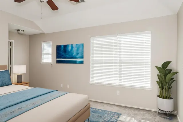 a bedroom with a bed a window and potted plant
