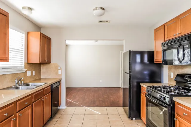 a kitchen with stainless steel appliances granite countertop a stove a sink and a refrigerator