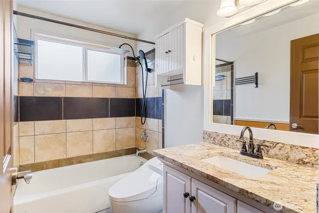 a bathroom with a granite countertop sink toilet and shower