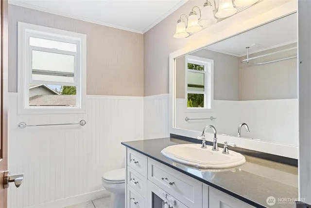 a bathroom with a granite countertop sink a toilet and a mirror