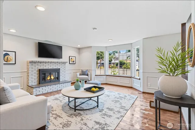 a living room with furniture a flat screen tv and a fireplace