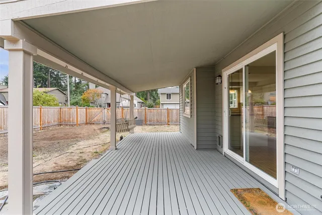 a view of a small house with yard and wooden fence
