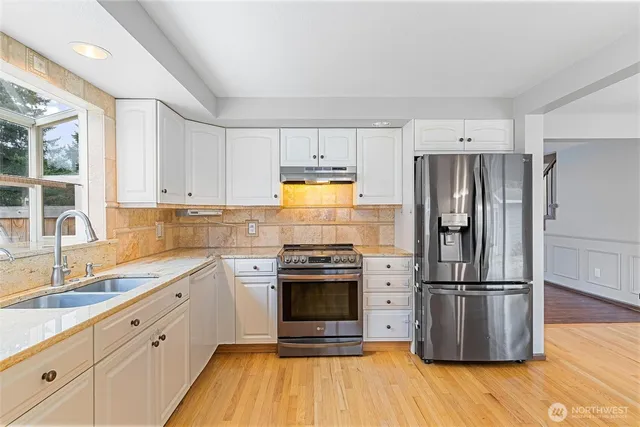 a kitchen with a refrigerator sink and wooden floor