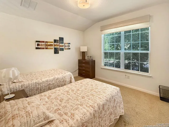 a bedroom with a large bed and a window