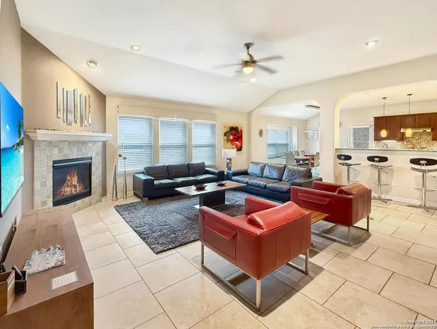 a living room with furniture a fireplace and a kitchen view