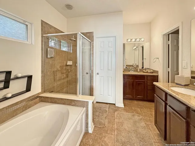 a spacious bathroom with a tub sink shower and mirror