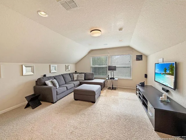 a living room with furniture flat screen tv and a large window