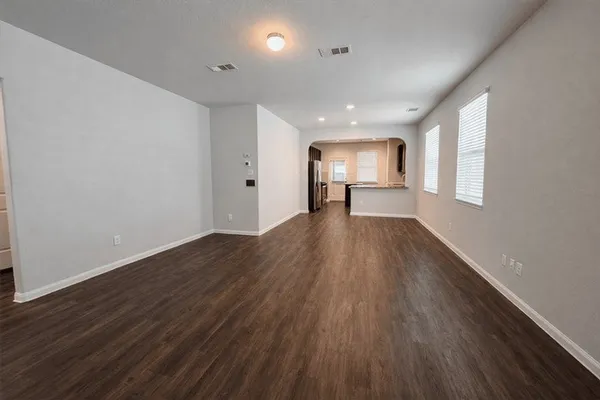 a view of a big room with wooden floor and windows
