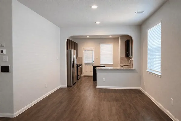 an empty room with wooden floor and a window