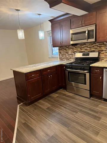 a kitchen with stainless steel appliances granite countertop a stove a sink and a microwave