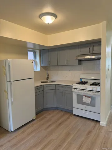 a kitchen with a white cabinets and wooden floor