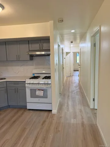a view of kitchen with a sink stove and cabinets