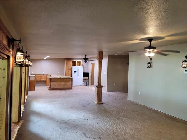 a view of a livingroom with a ceiling fan and kitchen view