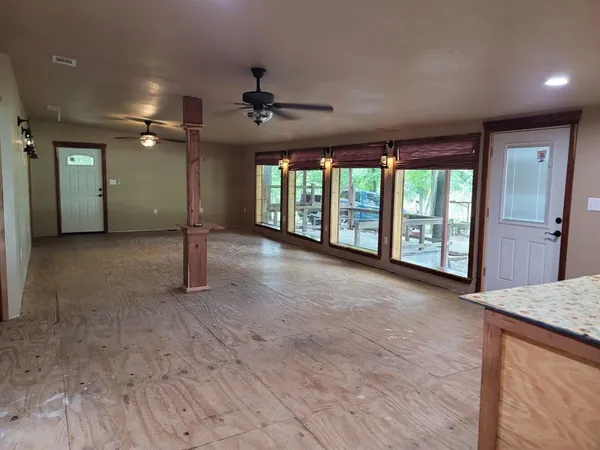 a view of an empty room with a fireplace and a large window