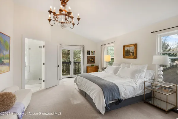 a bedroom with a large bed and a chandelier