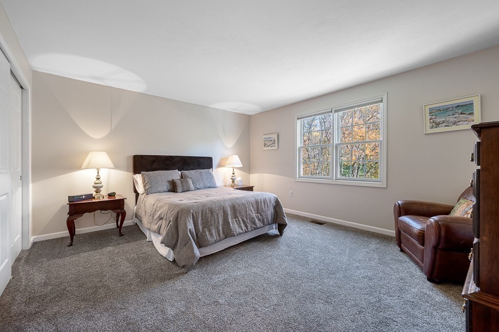 115 Ariel Circle, Unit 115 Sutton, MA 01590 - Photo 18 of 39 a spacious bedroom with a bed and a couch