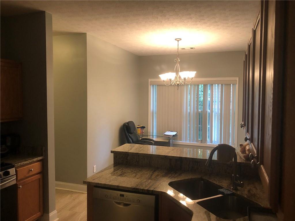848 Windy Mill Court Temple, GA 30179 - Photo 13 of 19 a kitchen with a sink and a stove top oven with wooden floor