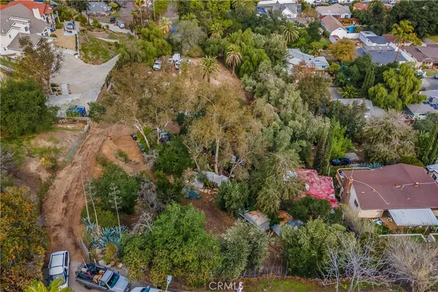 an aerial view of residential house with outdoor space and trees all around