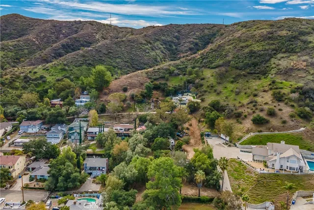 an aerial view of residential houses with outdoor space and trees