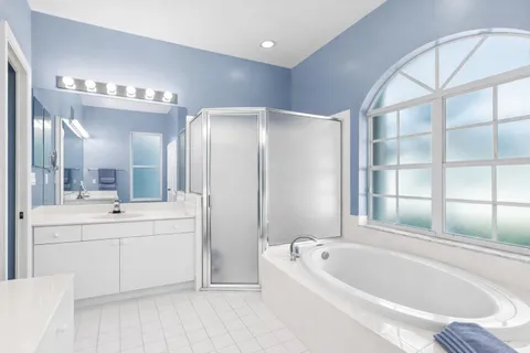 a bathroom with a bathtub a mirror a double vanity sink and vanity