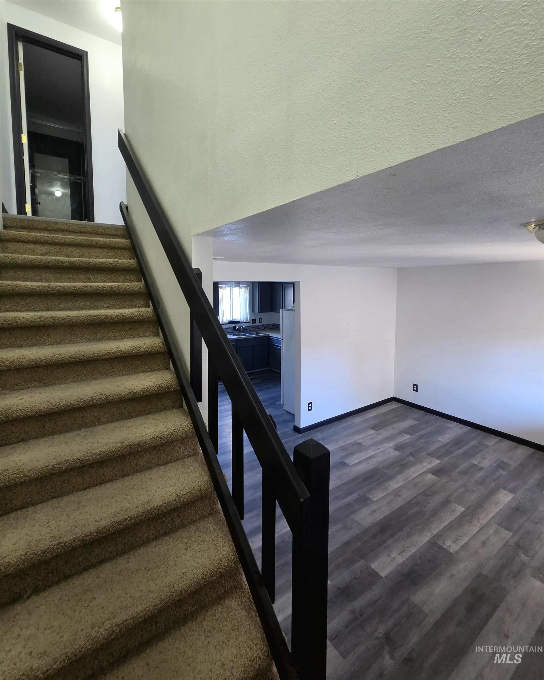 Carpeted staircase with dark wood-finish railing