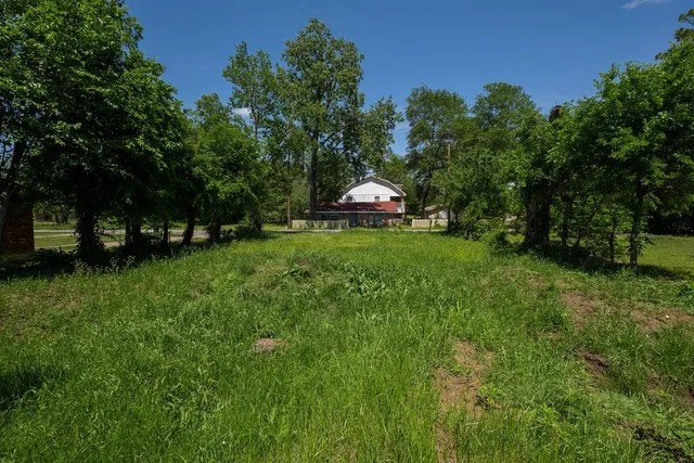 a front view of a house with a garden and trees