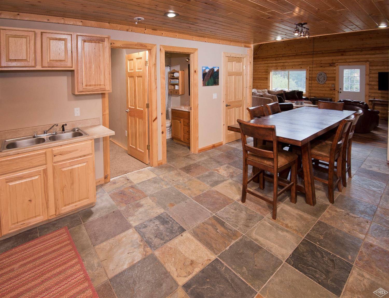 320 Mill Road Eagle, CO 81631 - Photo 6 of 24 a kitchen with stainless steel appliances granite countertop a stove a sink a dining table and chairs with wooden floor