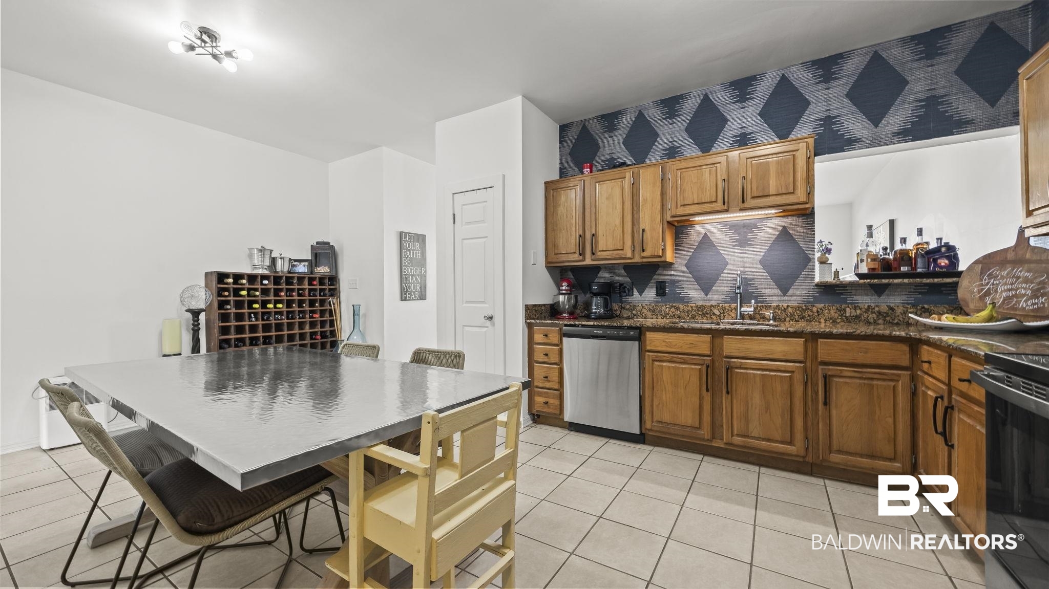 26063 Canal Road, Unit 2F Orange Beach, AL 36561 - Photo 25 of 36 Kitchen featuring tasteful backsplash, brown cabinets, stainless steel dishwasher, dark stone counters, and light tile patterned floors