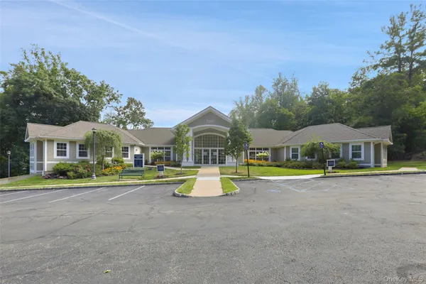a view of pool with lawn chairs and large trees
