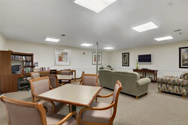 a living room with furniture a dining table and a flat screen tv