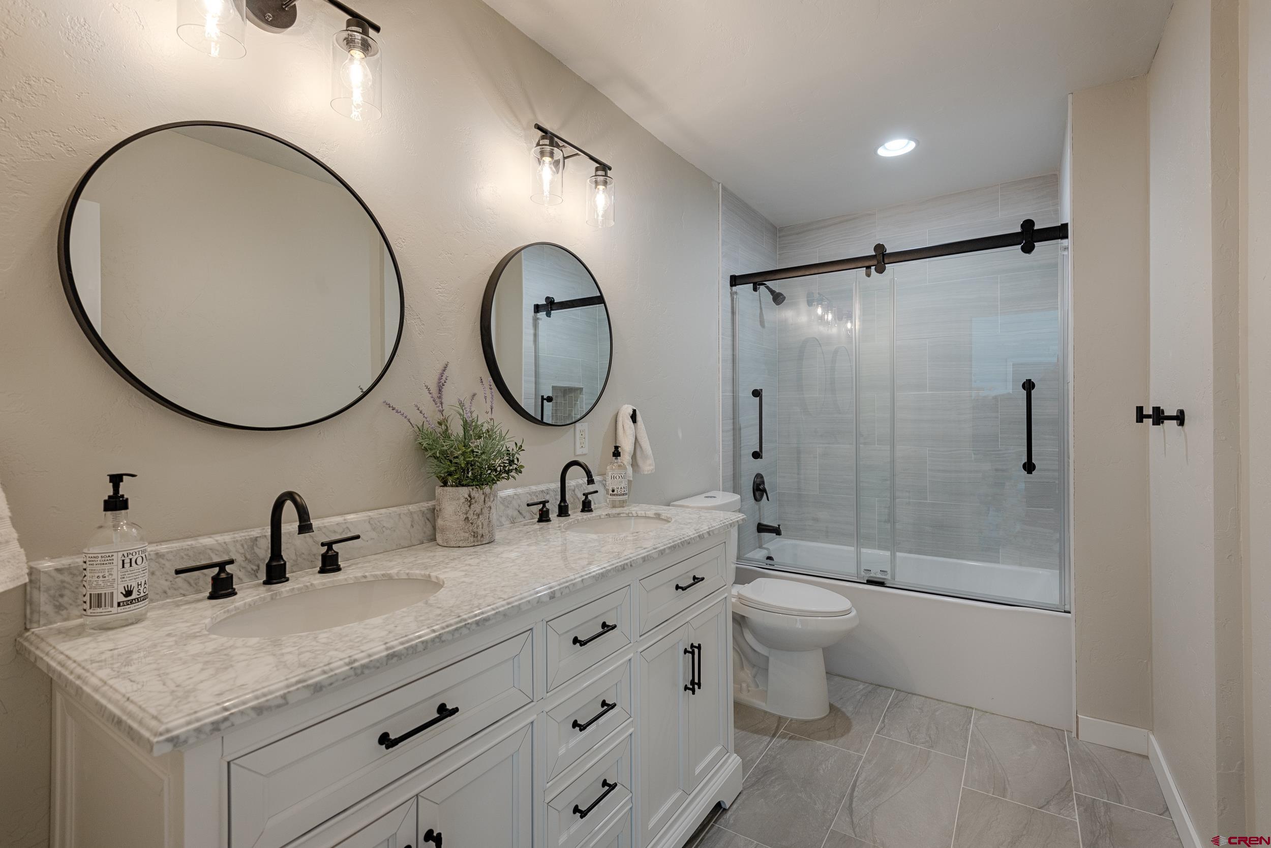 711 Terrace Drive Ridgway, CO 81432 - Photo 13 of 32 a bathroom with a double vanity sink toilet mirror and shower