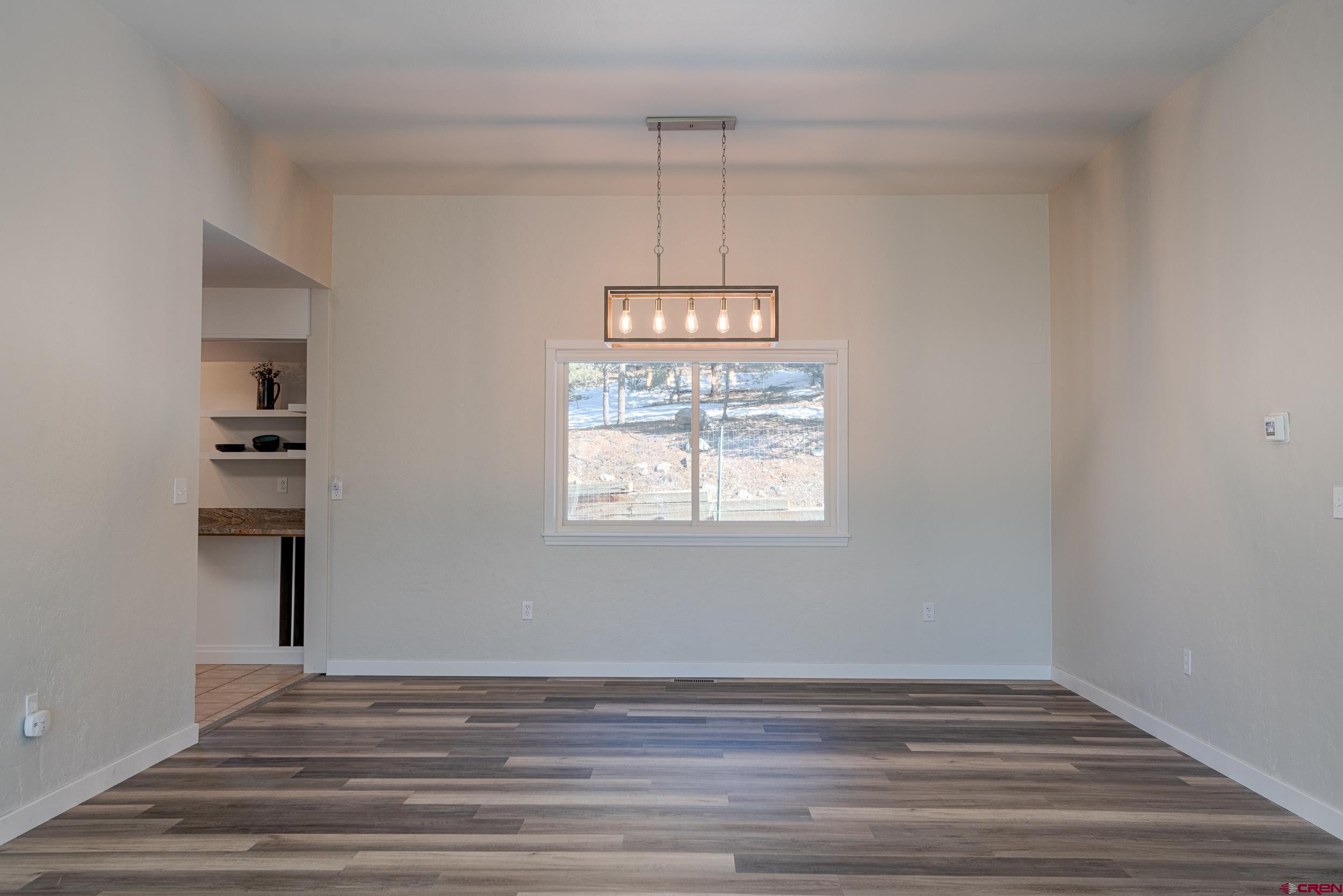 711 Terrace Drive Ridgway, CO 81432 - Photo 28 of 32 a view of a room with wooden floor chandeliers and kitchen view