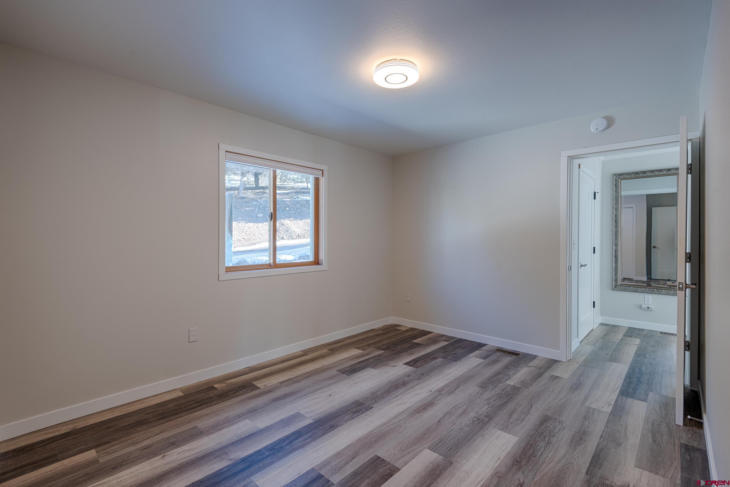 711 Terrace Drive Ridgway, CO 81432 - Photo 29 of 32 an empty room with wooden floor and windows