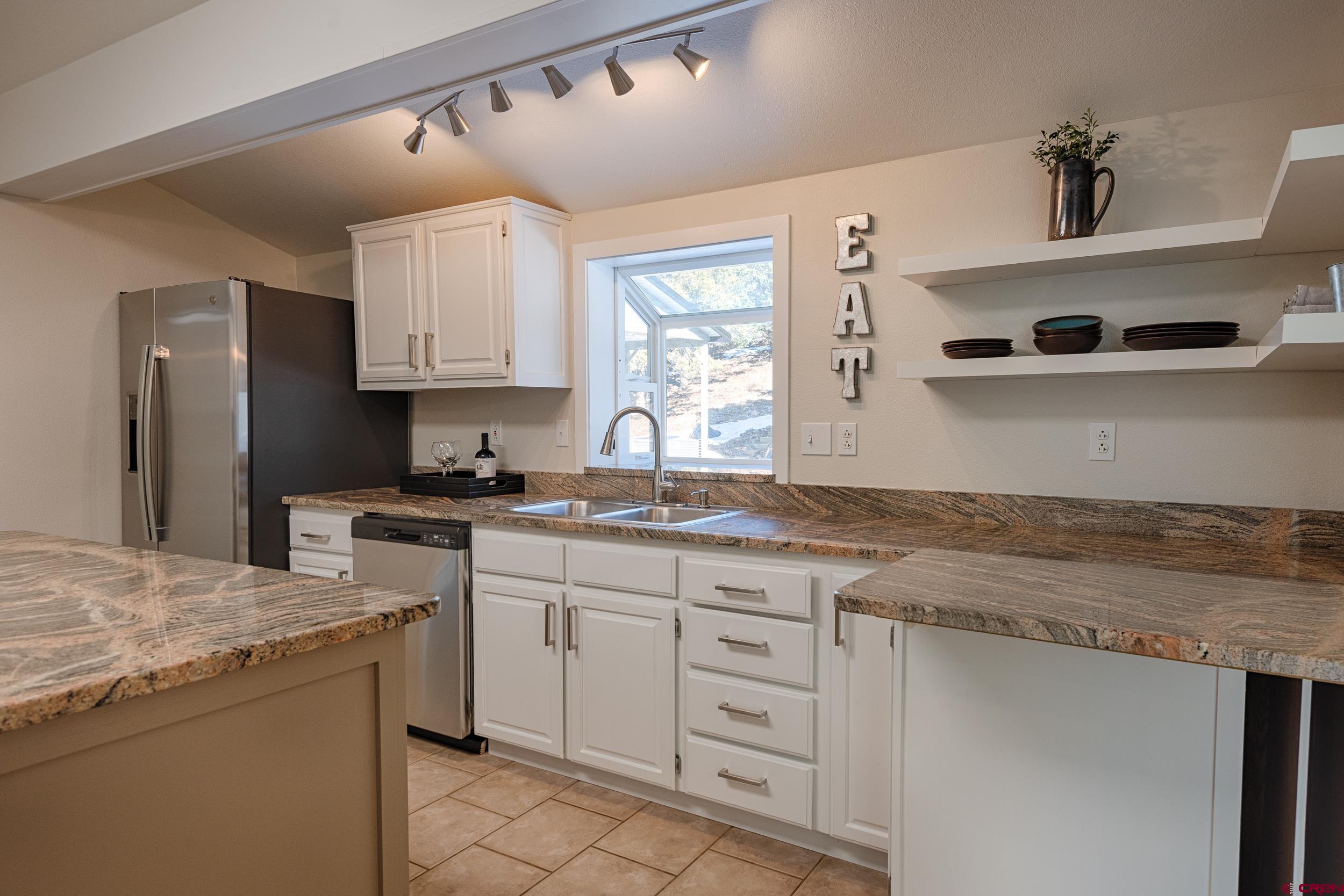 711 Terrace Drive Ridgway, CO 81432 - Photo 5 of 32 a kitchen with granite countertop a sink stainless steel appliances and cabinets