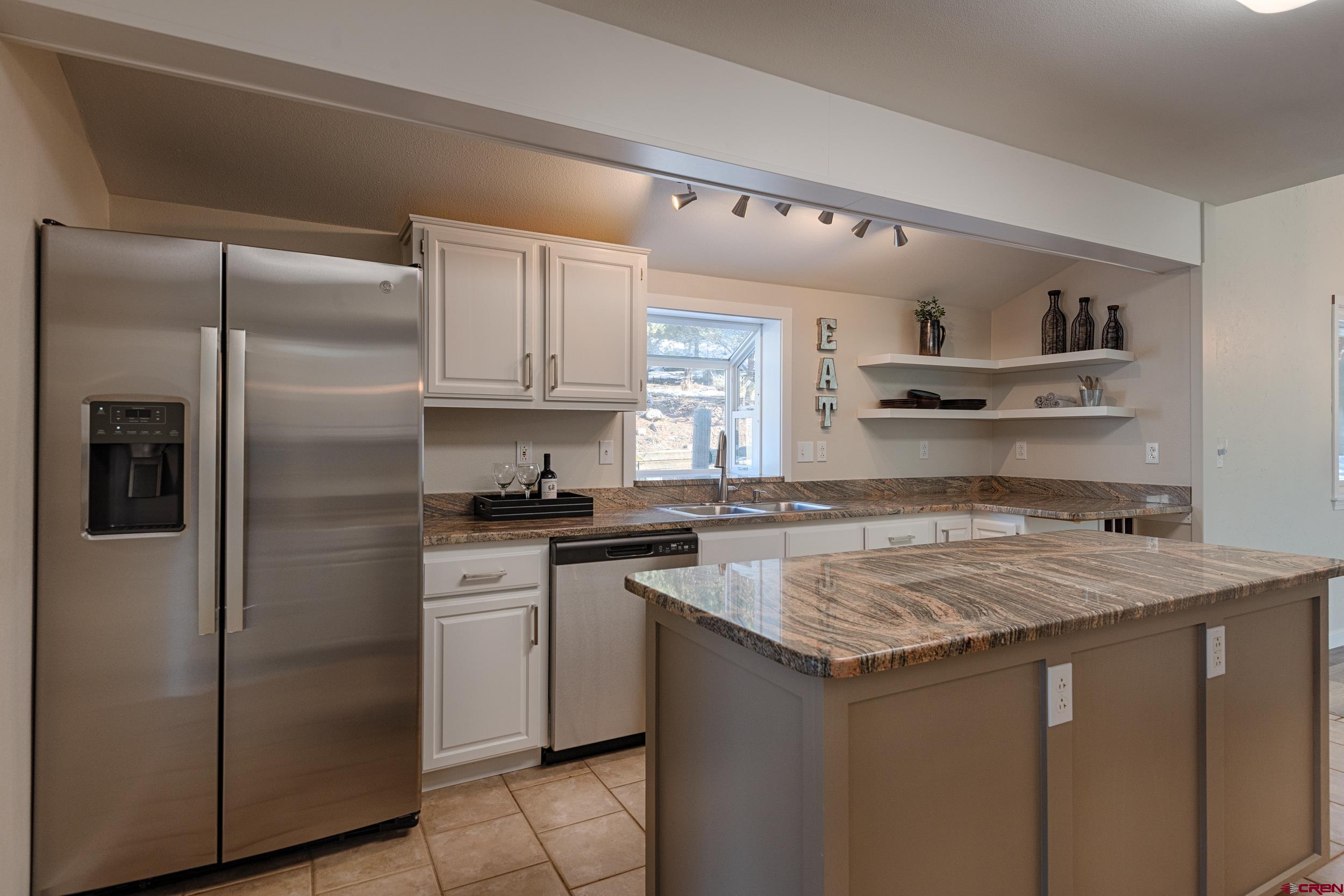 711 Terrace Drive Ridgway, CO 81432 - Photo 6 of 32 a kitchen with a refrigerator a sink and cabinets