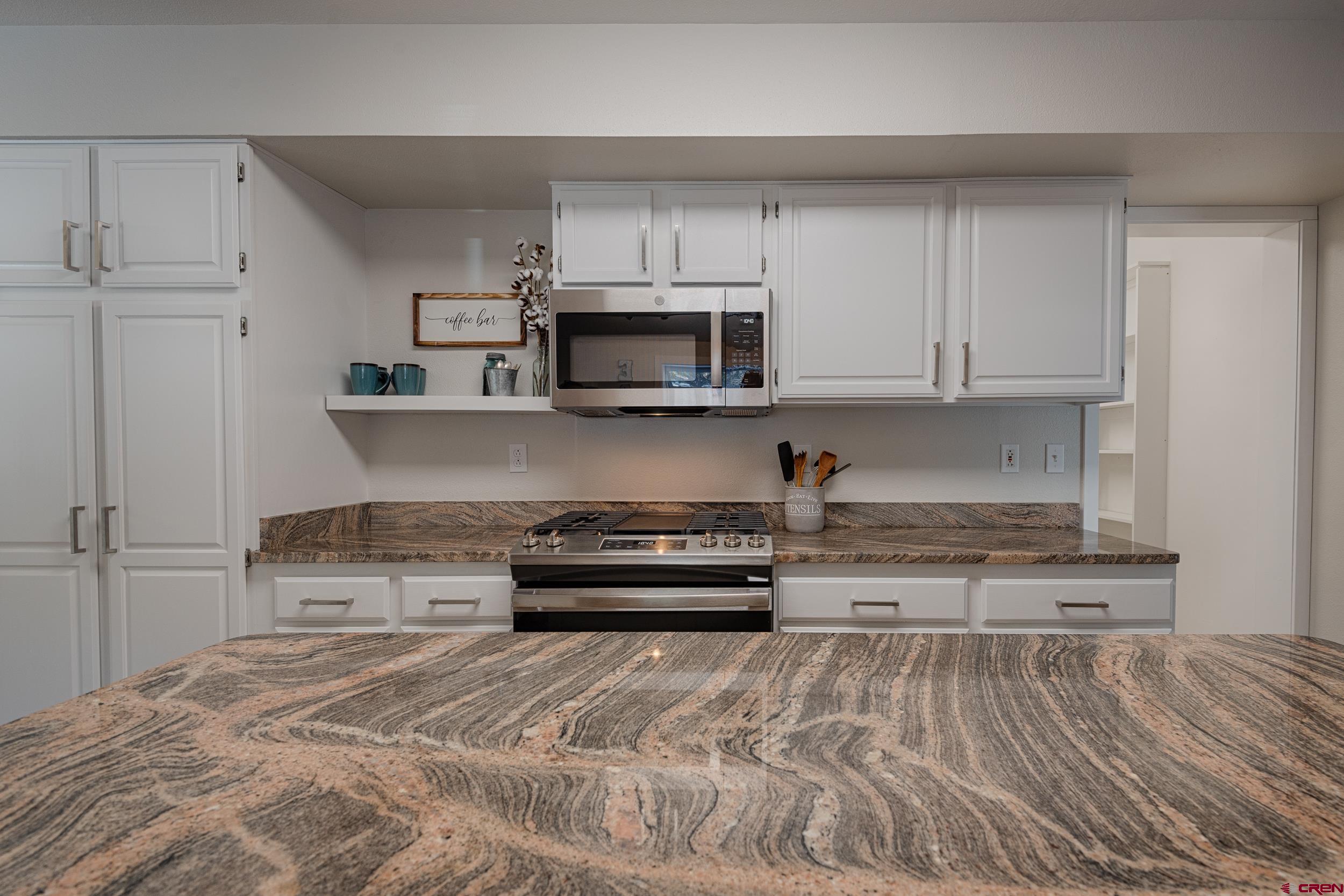 711 Terrace Drive Ridgway, CO 81432 - Photo 7 of 32 a kitchen with stainless steel appliances granite countertop a stove and a microwave oven