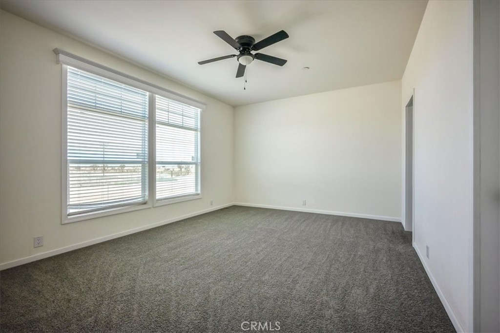 12076 Lager Road Phelan, CA 92371 - Photo 13 of 30 an empty room with a window and a ceiling fan