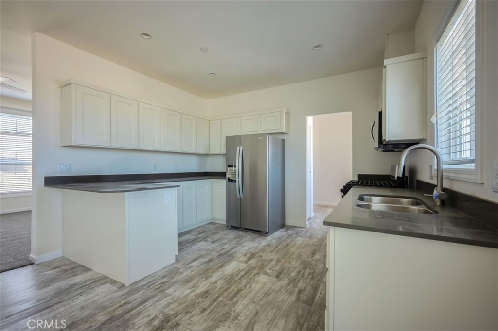 12076 Lager Road Phelan, CA 92371 - Photo 9 of 30 a kitchen with stainless steel appliances granite countertop a sink stove and refrigerator