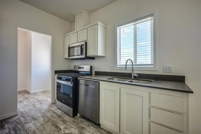 a kitchen with granite countertop a sink and cabinets