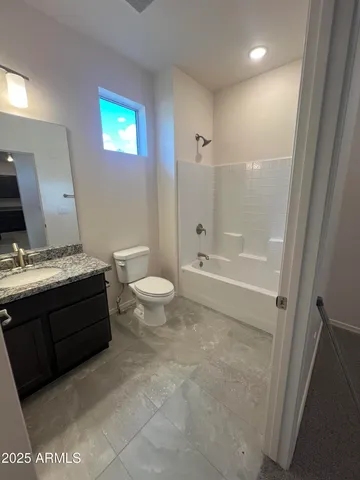 a bathroom with a granite countertop toilet a sink and a mirror