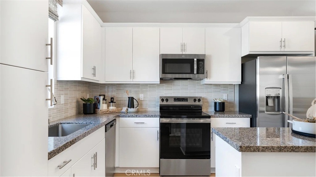 1210 Yeager Avenue Rialto, CA 92376 - Photo 2 of 24 a kitchen with stainless steel appliances granite countertop a refrigerator a stove a sink and white cabinets