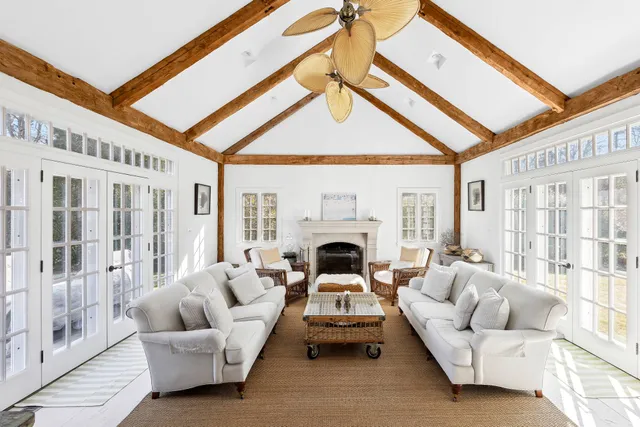 a living room with furniture a fireplace and a large window