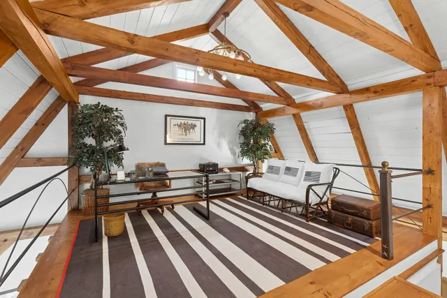 a living room with a bed and a large window with garden view