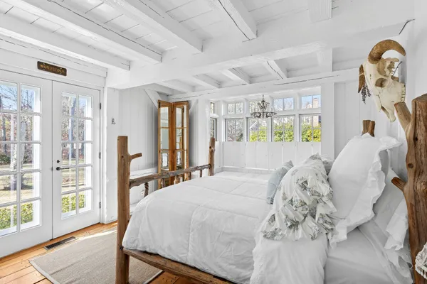 a bedroom with a large bed and large windows