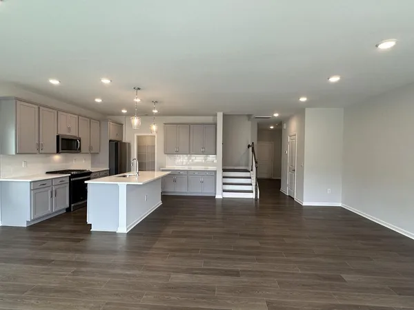 a large kitchen with stainless steel appliances a large counter top and a fireplace