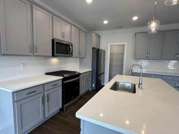 a kitchen with stainless steel appliances a refrigerator sink and microwave
