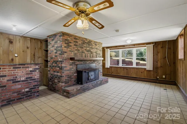 an empty room with windows and fireplace